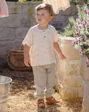 Load image into Gallery viewer, Child standing outdoors near a stone wall and potted plants

