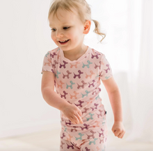 Load image into Gallery viewer, Child wearing a pink pajama with colorful dog pattern on a white background
