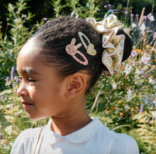 Load image into Gallery viewer, Child with decorative hair clips in a garden setting
