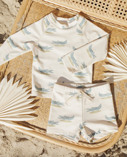 Load image into Gallery viewer, Children's outfit with alligator pattern on a woven surface
