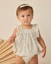 Load image into Gallery viewer, Baby wearing a floral romper standing next to wooden sticks on a neutral background
