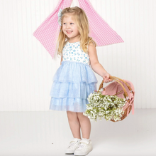 Load image into Gallery viewer, Young girl in a floral top and light blue skirt holding flowers and a pink bag on a white background
