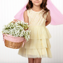 Load image into Gallery viewer, Young girl in a yellow dress holding a basket of flowers against a pink and white striped background
