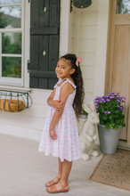 Load image into Gallery viewer, Young girl in a pink dress standing on a porch with a rabbit statue and potted plant.
