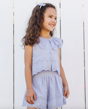 Load image into Gallery viewer, Young girl wearing a light purple outfit with ruffled top against a white wooden background
