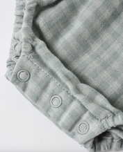 Load image into Gallery viewer, Close-up of a textured fabric garment with button details on a white background

