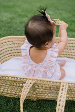 Load image into Gallery viewer, Baby in a pink dress sitting in a woven basket on grass
