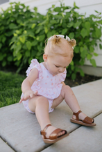 Load image into Gallery viewer, Baby sitting on a stone surface with greenery in the background
