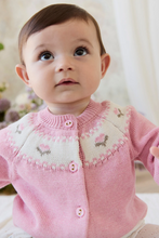 Load image into Gallery viewer, Baby wearing a pink knitted cardigan with floral patterns against a blurred background
