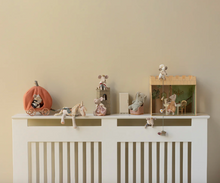 Load image into Gallery viewer, Decorative shelf with small figurines on a white cabinet against a beige wall

