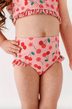 Load image into Gallery viewer, Child wearing a pink cherry-themed two-piece swimsuit on a white background
