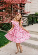 Load image into Gallery viewer, Young girl in a pink dress standing outdoors with cherry blossoms in the background

