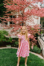 Load image into Gallery viewer, Young girl in a pink dress standing in front of a cherry blossom tree.
