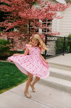 Load image into Gallery viewer, Young girl in a pink dress twirling on steps with cherry blossom trees in the background
