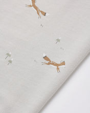 Load image into Gallery viewer, Close-up of a light beige fabric with a printed pattern of leaping brown foxes and small white flowers.
