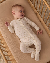 Load image into Gallery viewer, Baby looking to the side in a wooden crib, wearing a cream Hanukkah-print footie with legs crossed.
