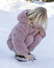 Load image into Gallery viewer, A young blonde girl crouching in the snow, wearing a dusty pink sherpa fleece hooded jacket and matching pink corduroy pants.
