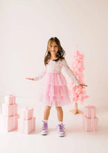 Load image into Gallery viewer, Front view of a child in a Sugar Plum tutu dress with arms held out beside pink wrapped gifts.
