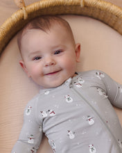 Load image into Gallery viewer, Close-up of a smiling baby wearing a gray snowman-print zip footie while lying in a woven basket.
