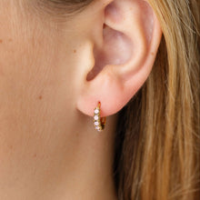 Load image into Gallery viewer, Close-up of a gold-tone pink opal hoop earring worn on an earlobe.
