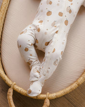 Load image into Gallery viewer, A baby footed sleeper in cream with a brown pumpkin and pear pattern, shown on a baby lying in a woven bassinet.
