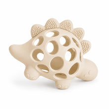 Load image into Gallery viewer, A beige silicone dinosaur teether toy with circular cutouts and textured bumps along its back, shown on a clean white background.
