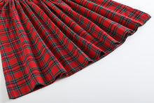 Load image into Gallery viewer, A close-up of a red tartan plaid fabric, likely a pleated skirt or dress, shown on a clean white background.
