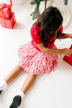 Load image into Gallery viewer, Overhead view of a child reaching toward a gift, with the pink bow-and-stripe tulle skirt spread over their legs.
