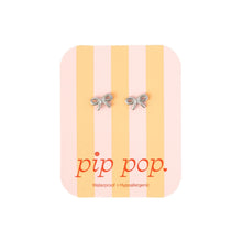 Load image into Gallery viewer, Silver-tone bow stud earrings on a pink and yellow striped Pip Pop display card.
